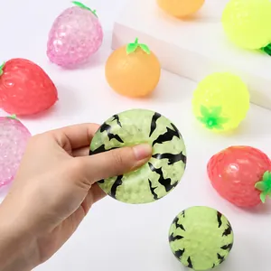 Close-up view of watermelon fruit patterned squishy toy being squeezed for stress relief