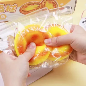 Close-up of hands squeezing a realistic egg tart slow rebound squishy stress toy