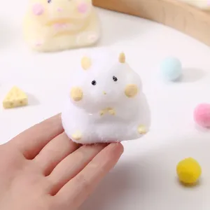 Close-up of white fluffy hamster squishy toy being squeezed by hand
