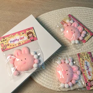 Detalle de tres peluches antiestrés con forma de conejo rosa en paquetes individuales.