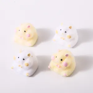 Detailed view of four cute furry hamster-shaped TPR squishy toys in white and yellow