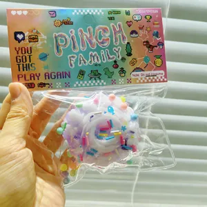 Close-up detail of a purple cake squishy toy inside its colorful pixel art packaging