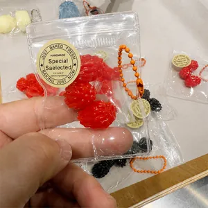 Close-up view of red raspberry fruit squishy toy in a mini clear plastic bag detail