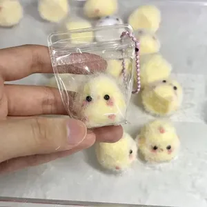 Detailweergave van een mini geel pluizig stressspeelgoed in een plastic zakje met ketting