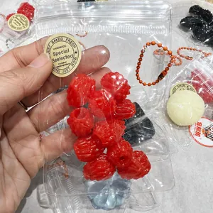 Close-up view of a red berry-shaped stress relief squeeze toy inside a clear bag