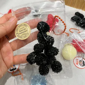 Detailed view of a realistic black raspberry squeeze toy packaged in a mini clear zipper bag