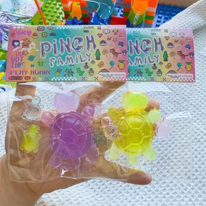 Nahaufnahme von zwei transparenten Schildkröten-Quetschspielzeugen in bunter Verkaufsverpackung.