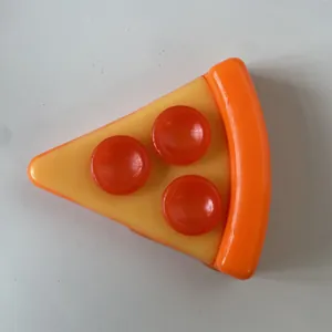 Macro view of a realistic pizza slice squishy toy featuring three pepperoni toppings