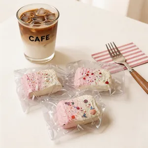 Primer plano de un squishy de pastel rosa y crema con chispas decorativas y detalles de concha