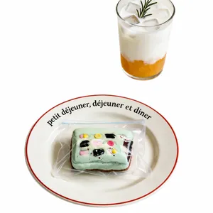 Charme de jouet à presser artisanal en silicone vert en forme de dessert sur une assiette