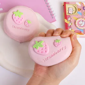 Close-up of pink strawberry souffle silicone squishy toy being squeezed for stress relief