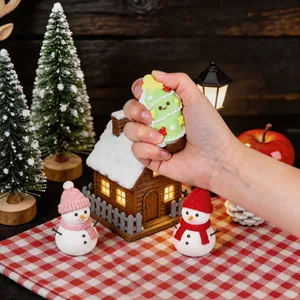 Nahaufnahme einer Hand, die ein süßes Weihnachtsbaum-Silikon-Stressspielzeug drückt