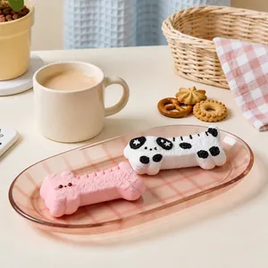 Close-up view of cute dog and bone-shaped silicone squishy toys on a decorative pink tray
