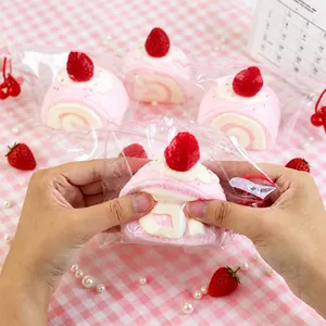 Détail en gros plan de mains pressant un jouet squishy en forme de roulé fraise