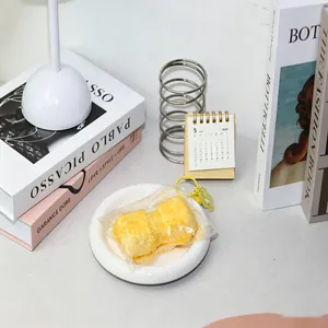 Primer plano de un juguete de silicona con forma de pastel de arroz sobre un plato blanco.