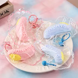 Close-up of pastel banana squishy toys in decorative lace packaging on a white plate