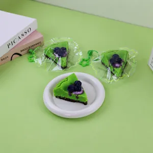 Detail of green blueberry cake squishy toys on a plate and in star-shaped packaging.