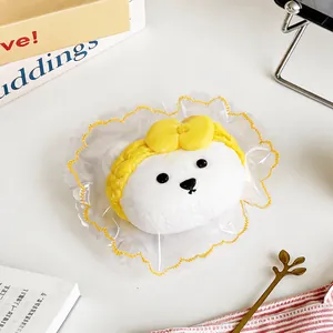 Gros plan détaillé d'un jouet squishy tête d'ours blanc avec un nœud jaune et un sac