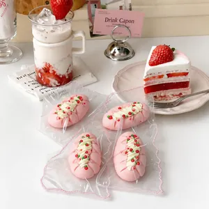 Close-up detail of handmade pink strawberry cream cake squishy toys in clear plastic wrap