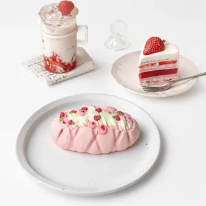 Detailed macro view of a realistic pink strawberry cream cake squishy toy on a white plate