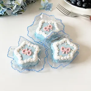 Close-up detail of blue star-shaped cake squishy toys with pink bows in clear wrappers