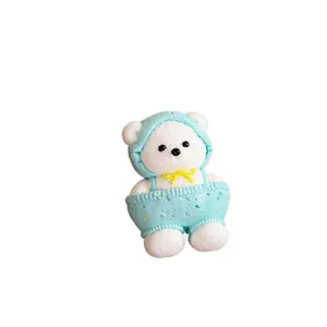 Adorable jouet ours squishy blanc portant une salopette bleue en silicone de qualité alimentaire