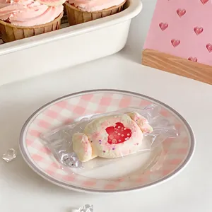 Gros plan d'un jouet à presser en silicone rose en forme de bonbon sur une assiette