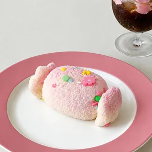 Primo piano di un giocattolo antistress in silicone a forma di caramella su un piatto rosa
