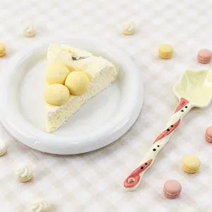 Detaillierte Nahaufnahme eines realistischen Käsekuchen-Quetschspielzeugs auf einem weißen Teller