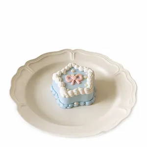 A cute blue star-shaped cake squishy toy decorated with a pink bow and pearls on a plate