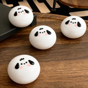 Close-up of four white dog-shaped silicone squishy toys on a natural wood surface