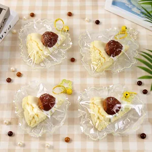 Jouets squishy gâteau aux marrons réalistes avec porte-clés et clochettes jaunes en détail.