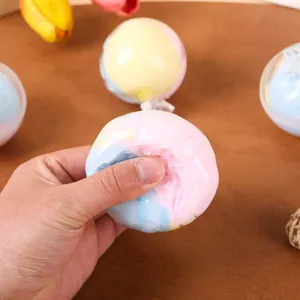 Handmade macaron colored squishy stress relief toy being squeezed to show softness