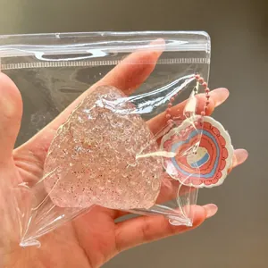 Close-up detail of a large pink glitter strawberry stress relief squishy toy in clear bag