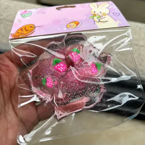 Λεπτομέρεια ροζ glitter squishy πατούσα γάτας με φράουλες σε διαφανή συσκευασία