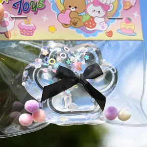 Detail view of a clear paw-shaped squishy toy with glitter and a black bow in cute packaging.
