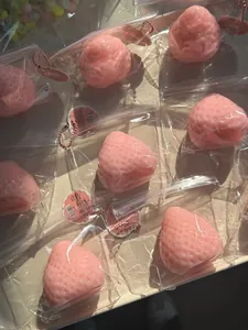 Vue détaillée de jouets spongieux en forme de fraise rose dans des sacs.