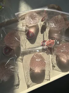 Détail de jouets de stress en forme de fraise rose pailletée dans des sacs clairs