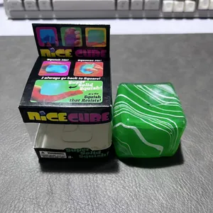 Detailansicht des grünen Nice Cube Squishy-Spielzeugs mit Marmormuster und Originalverpackung.