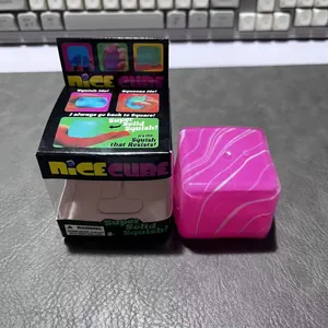 Rosa Marmor Nice Cube Squishy Stressabbau Spielzeug neben seiner Einzelhandelsverpackung gezeigt
