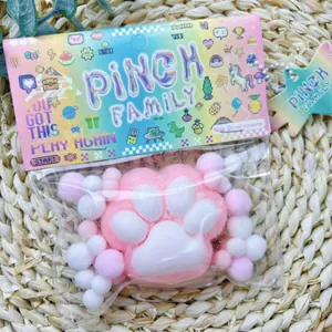 Close-up of pink flocked cat paw squishy toy in colorful Pinch Family packaging