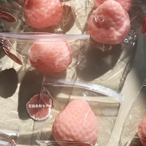 Realistic pink strawberry squeeze toy for stress relief in individual packaging