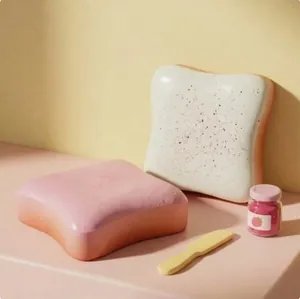 Nahaufnahme von süßen rosa und weißen Toast-Squishy-Spielzeugen mit Marmelade