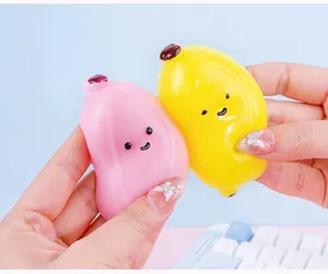 Detailed view of two colorful banana-shaped squishy stress relief toys held in hands