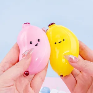 Cute pink and yellow banana squishy stress relief toys with faces held in hands