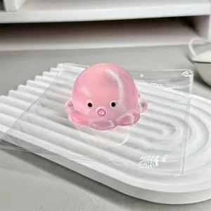 Detail showing the cute pink translucent octopus squishy toy on a white display tray