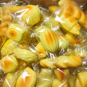Macro view of realistic slow rebound squishy bread toys in individual clear packaging.