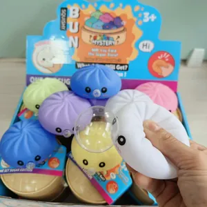 Gros plan d'une main pressant un jouet squishy en forme de brioche blanche de set