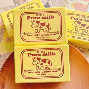 Detailed view of yellow butter block squishy toy with vintage cow label design