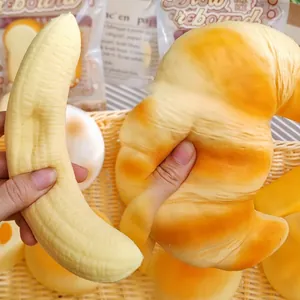 Detail view showing the soft slow-rebound texture of a croissant and banana squishy toy.